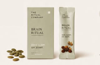 A box and a daily sachet labeled Nourish Ritual by My Store are shown with Mamra almonds, seeds, and nuts placed beside them on a light background.