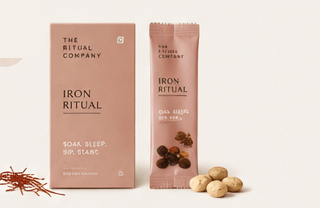 A pink box and matching packet labeled The Strength Ritual from My Store, with some round tablets, walnuts, and loose herbs or spices displayed in front—perfect for incorporating into your nourishing morning routine or Strength Ritual.